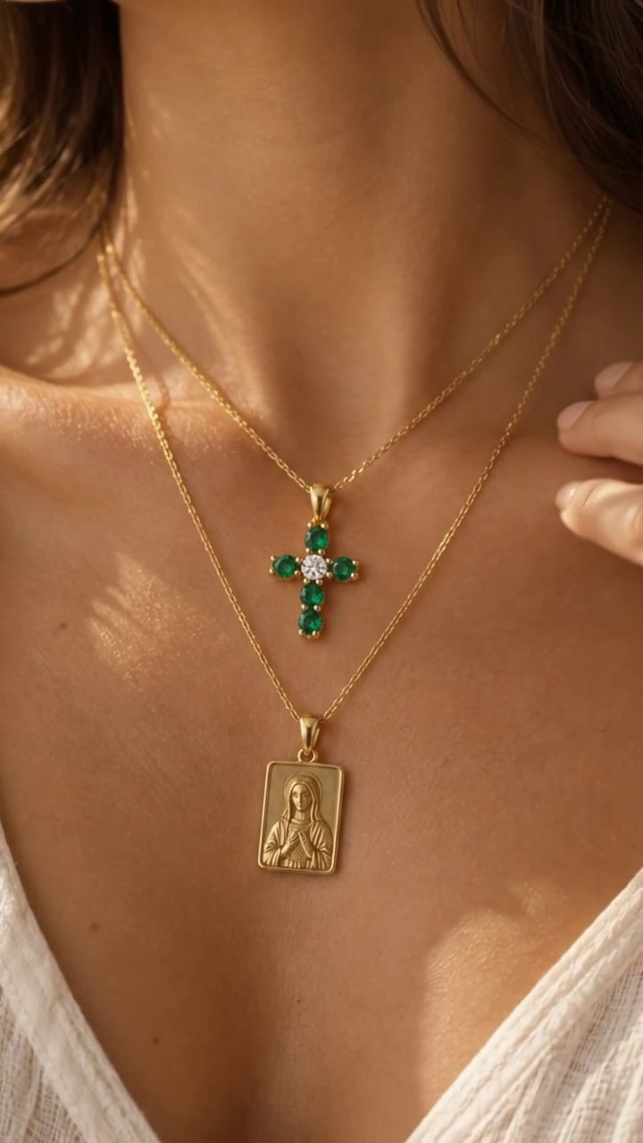 The Faith Cross esmeralda worn, layered with a gold medallion