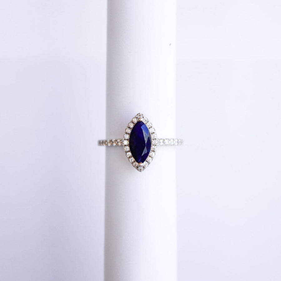 Ring with a blue sapphire on a white background marquise cut white gold